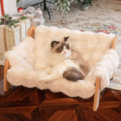 Cream and white cat lounging on an elevated wooden sofa bed with plush faux fur cushioning.