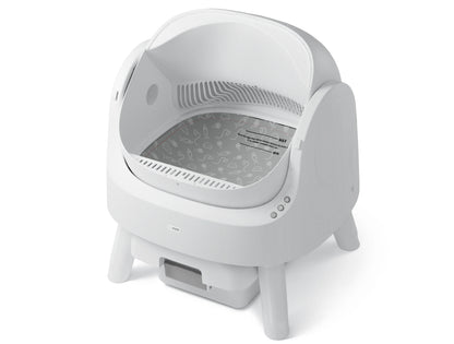White automatic litter box with domed hood, open top view showing gray interior, removable waste drawer, and control buttons.